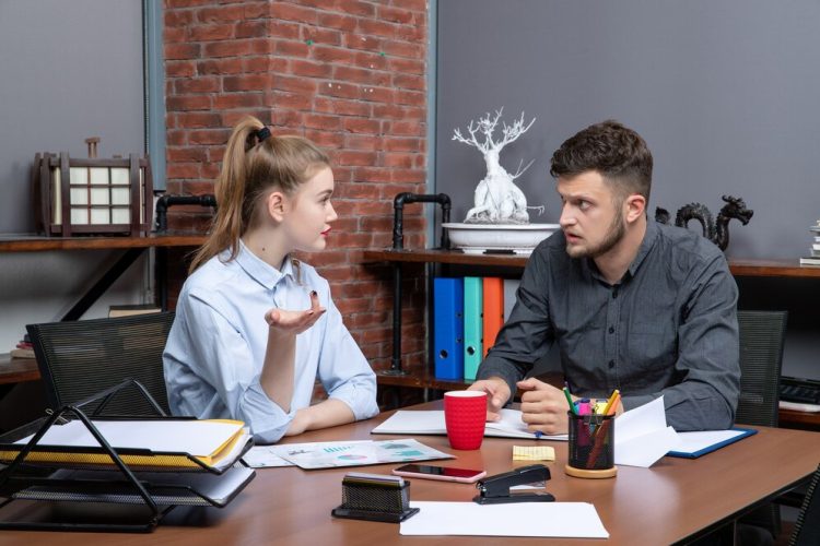 front-view-hardworking-confident-professional-team-discussing-one-issue-documents-office_140725-105976